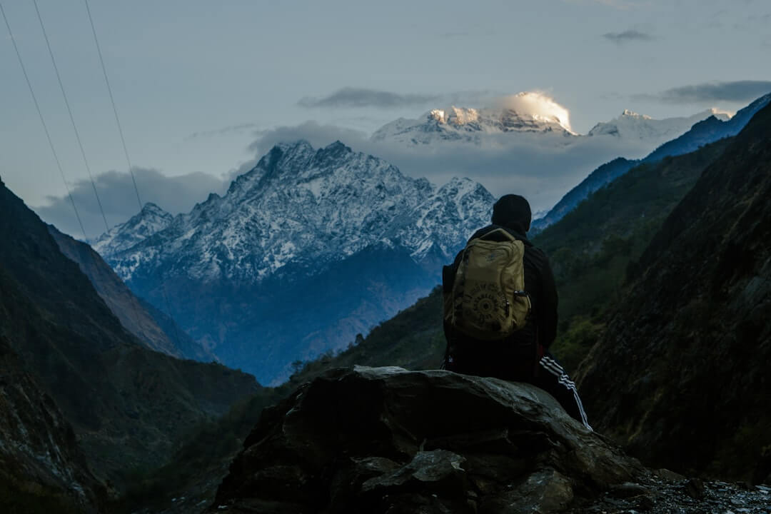 Trekker resting on a rocky Nepal mountain trail, looking tired